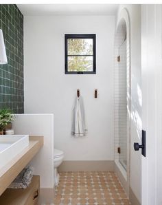 a bathroom with a sink, toilet and bathtub next to a window in the wall