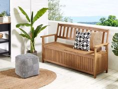 a wooden bench sitting on top of a hard wood floor next to a potted plant