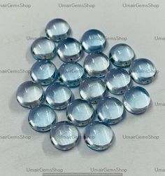 many clear glass beads on a white surface with the words umbreenshop written below them