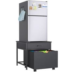 a white refrigerator freezer sitting on top of a black filing cabinet next to a gray drawer