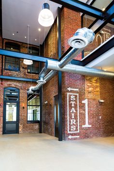 the inside of a building with exposed pipes and lights hanging from it's ceiling