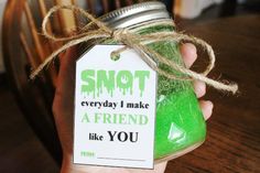 a person holding a jar with green liquid in it and a tag that says, snot everyday i make a friend like you