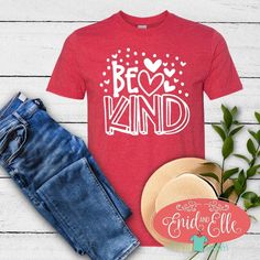 a t - shirt with the words be kind on it next to jeans and hat