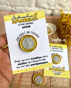 a person holding up a coin in front of some other coins on a table with gold and white decorations