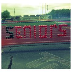 there is a sign that says soccer written in red and black letters on the side of a fence