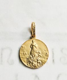 "This beautiful 18K gold vermeil Saint Mary Magdalene medal depicts her being \"Carried by Angels,\" as she was 7 times a day when she lived in La Sainte-Baume for thirty years in contemplation and prayer. The medal measures 20mm in diameter. The reverse is decorated with a lily flower.  In the Cave of La-Sainte-Baume there is a beautiful statue of Mary Magdalene raised up by angels. It is the work of L.J. Alexandre (c. 1878). Pilgrims come from all over the world to her cave to pray: \"Marie-Ma A Lily Flower, Saint Mary Magdalene, Statue Of Mary, Catholic Saint, Maria Magdalena, Mary Magdalene, Saints Medals, Pretty Pendant, Guardian Angels