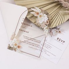 an image of wedding stationery with fan and flowers