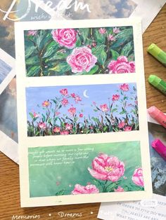 some pink flowers and green leaves on top of a wooden table with crayons