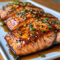 three pieces of salmon on a plate with sesame seeds