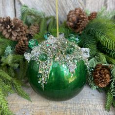 a green christmas ornament hanging from a tree