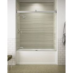 a white bath tub sitting next to a tiled wall