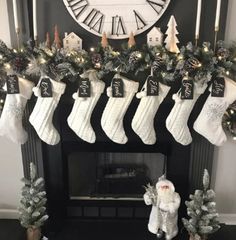 christmas stockings hanging from the mantle with decorations around it and a clock on the wall in the background