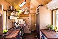 the interior of a tiny home with wood counter tops and cabinets, along with an open kitchen area