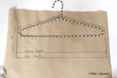 a piece of paper with a drawing of a hanger on it and some scissors next to it