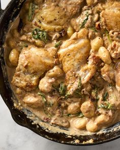 a skillet filled with chicken and white beans