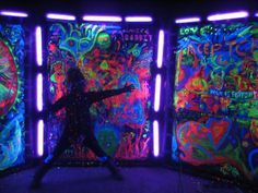 a person standing in front of some colorful wallpapers with neon lights on them