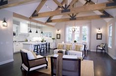 a living room filled with furniture next to a kitchen and breakfast nook in a home