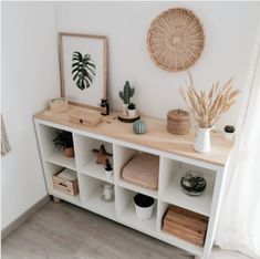 a white shelf with plants and other items on it