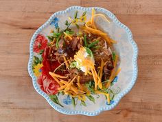 a white and blue plate topped with food on top of a wooden table