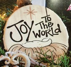 a wooden ornament with the words joy to the world on it