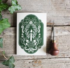 a green and white card sitting on top of a wooden table next to a pipe