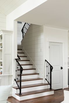 there is a stair case in the living room with white walls and wood flooring