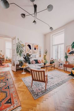 a living room filled with furniture and lots of plants on top of the windowsill