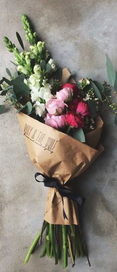 a bouquet of flowers wrapped in brown paper