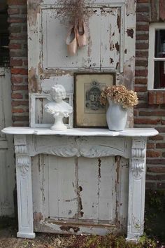 an old fireplace with some vases and flowers on it