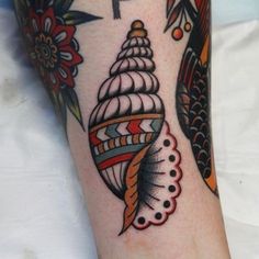 a close up of a person's foot with a tattoo on it and an image of a sea shell