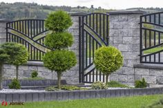 an outdoor garden with trees and bushes in front of a stone wall that says bopota 24