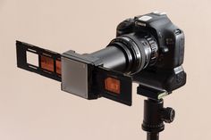 a camera is attached to a tripod with a lens on it's side