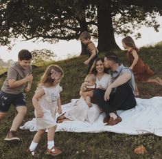 a group of people sitting on top of a blanket