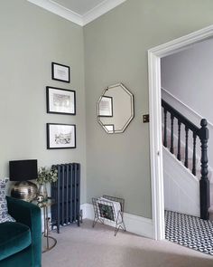 a living room filled with furniture and framed pictures on the wall next to a stair case