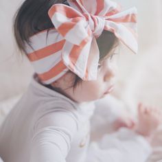 a baby girl with a bow on her head