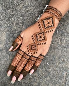 a woman's hand with hennap and flowers on the palm, showing her intricate