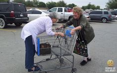 two older women pushing a shopping cart in a parking lot with other cars behind them