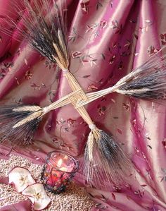 a cross on top of a purple cloth with water drops around it and some other items in the background