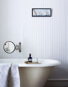 a bath tub sitting under a bathroom mirror next to a wall with the word bath on it