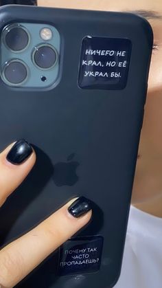 a woman's hand holding up an iphone case with stickers on the back