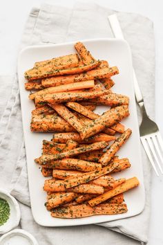 a white plate topped with carrots covered in seasoning