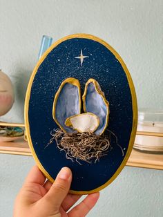 a hand holding up an ornament shaped like a pair of shoes