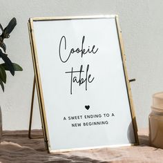 a sign that says cookie table next to a vase with some flowers in it and a jar