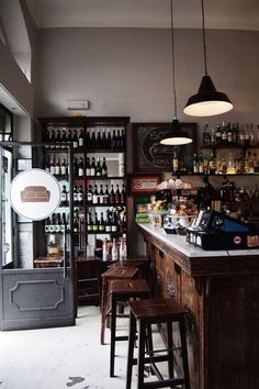 an empty bar with stools and bottles on the shelves