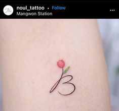 a small tattoo on the back of a woman's thigh with a single rose