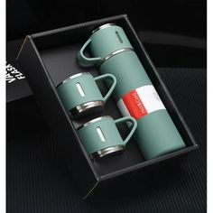 two green coffee mugs in a black box