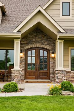 a house with stone and wood trimmings on the front door, windows, and sidelights