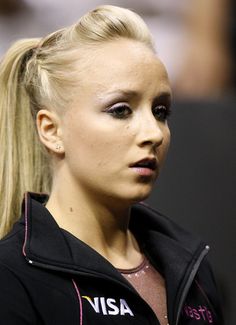 a woman with blonde hair and makeup looks off to the side while wearing a black jacket