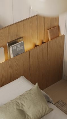 there is a bed with two books on the headboard and a lamp next to it