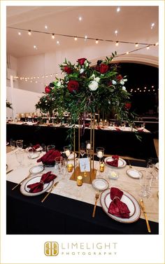 the table is set with red and white flowers